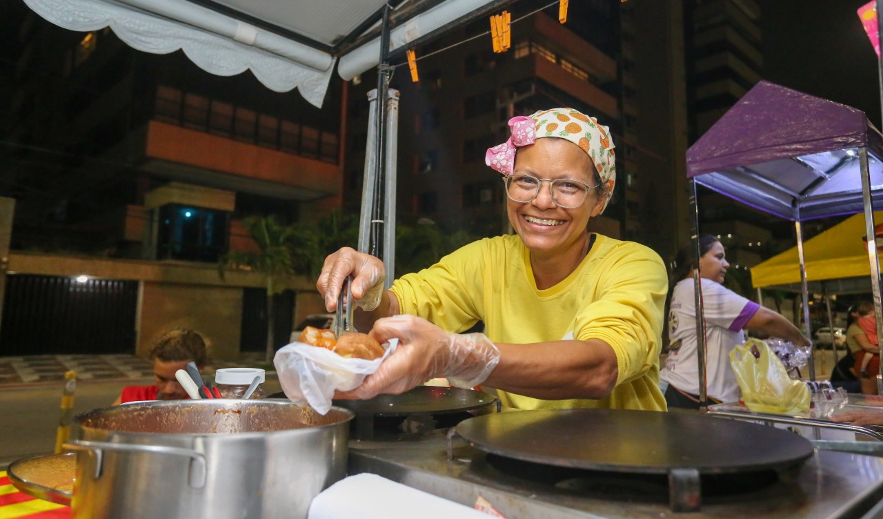 Mauriceia posa para a foto preparando um sanduíches